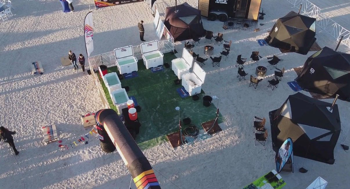 Aerial view of cold plunges on turf beside sauna tents