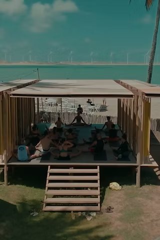 Raised timber deck with a movement class in progress by the water